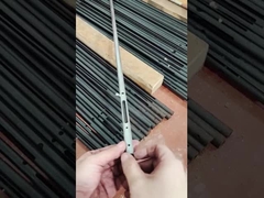 Un hombre muestra un pequeño componente hecho de tubo de acero al carbono